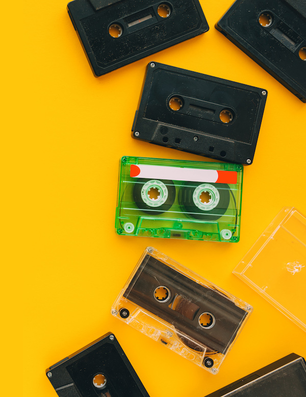 Top view of audio cassettes on bright yellow background with copy space, minimalistic composition